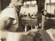 Bob Hall, a young man with a big smile looking at the photographer while working in the Ray Mailing Cannery