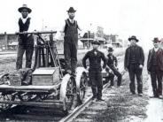 Chinese workers on the railroad as repair crew, men dressed in suits and hats standing around the railroad - year unknown