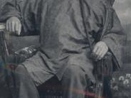 Chinese man - year unknown, he seated and dressed is in traditional dress with a single long braid and a hat