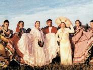 Nine Fiesta Mexicana dancers in traditional Ballet Folclorico costumes with colorful skirts