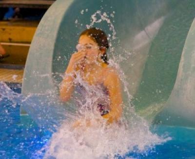 Girl jumping in the water plugging her nose