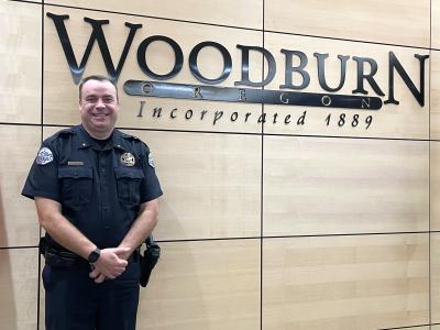 police chief standing in front of woodburn sign